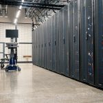 Armários metálicos com servidores, dispositivos de rede e cabos em um datacenter moderno