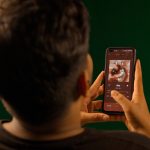 Pessoa usando um smartphone para ouvir música em um aplicativo de streaming.