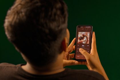 Pessoa usando um smartphone para ouvir música em um aplicativo de streaming.