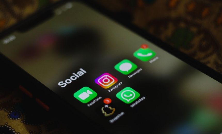 Close de um smartphone exibindo ícones de aplicativos de redes sociais na tela