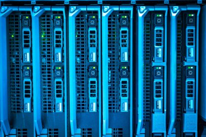 Racks de servidores iluminados em um data center, representando infraestrutura para processamento computacional de larga escala.